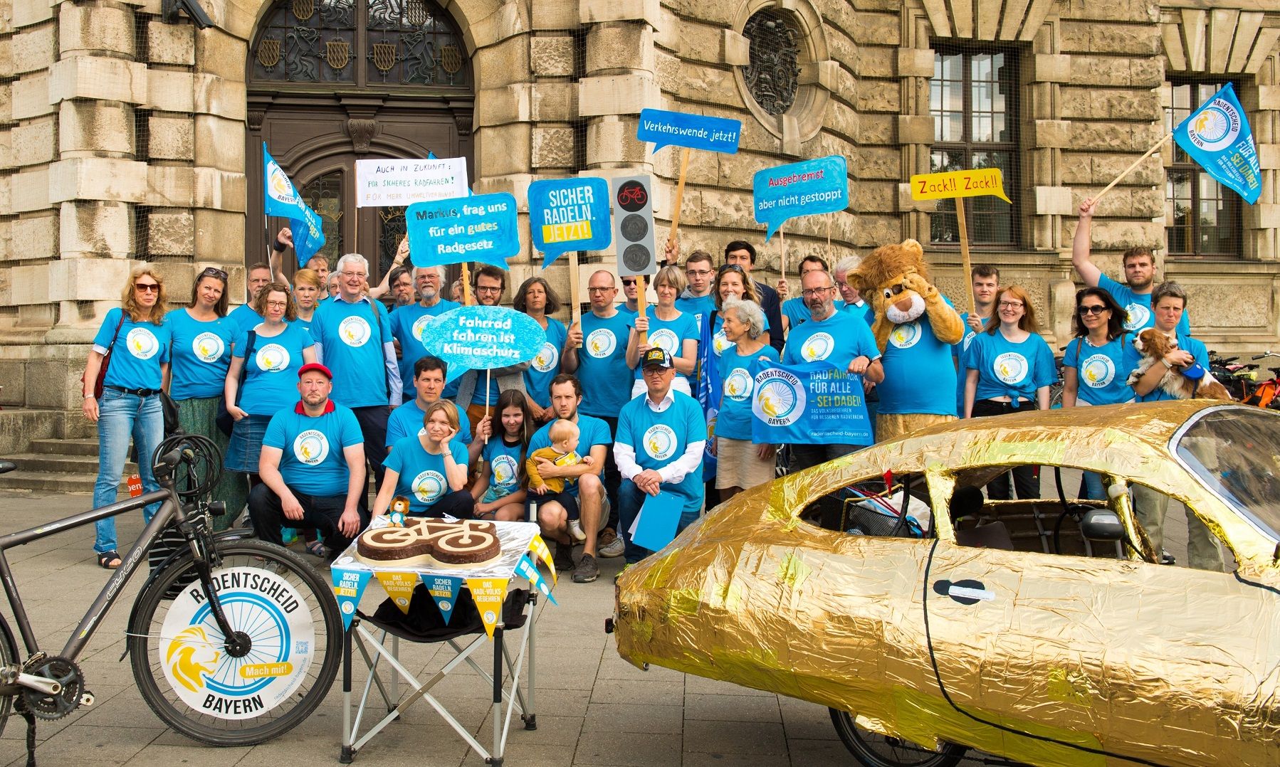 Bündnis Radentscheid mit blauen T-Shirts und Schildern vor dem dem Justizpalast München