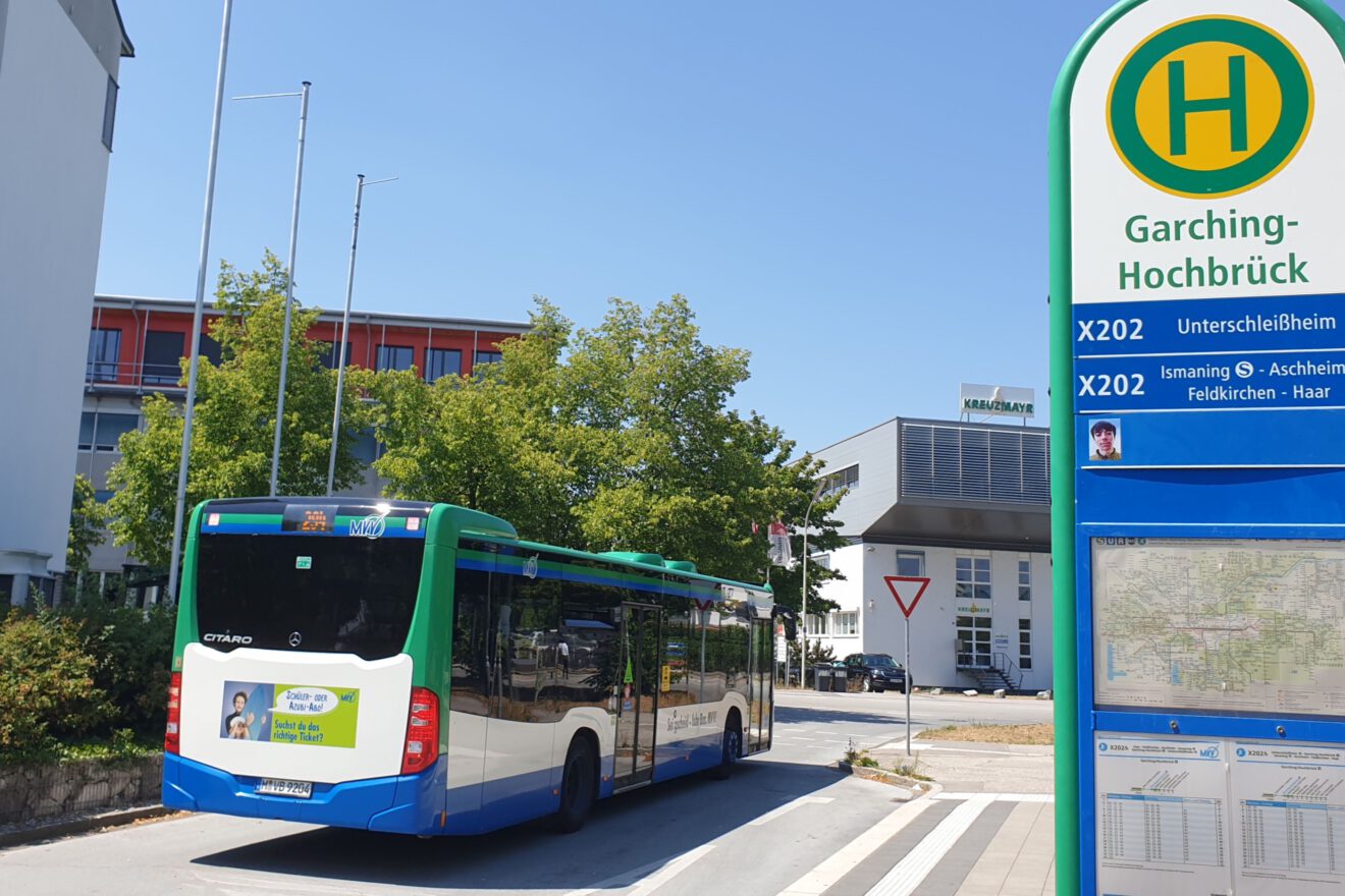 Gelenkbus neben einer Expressbus-Haltestelle des MVV.