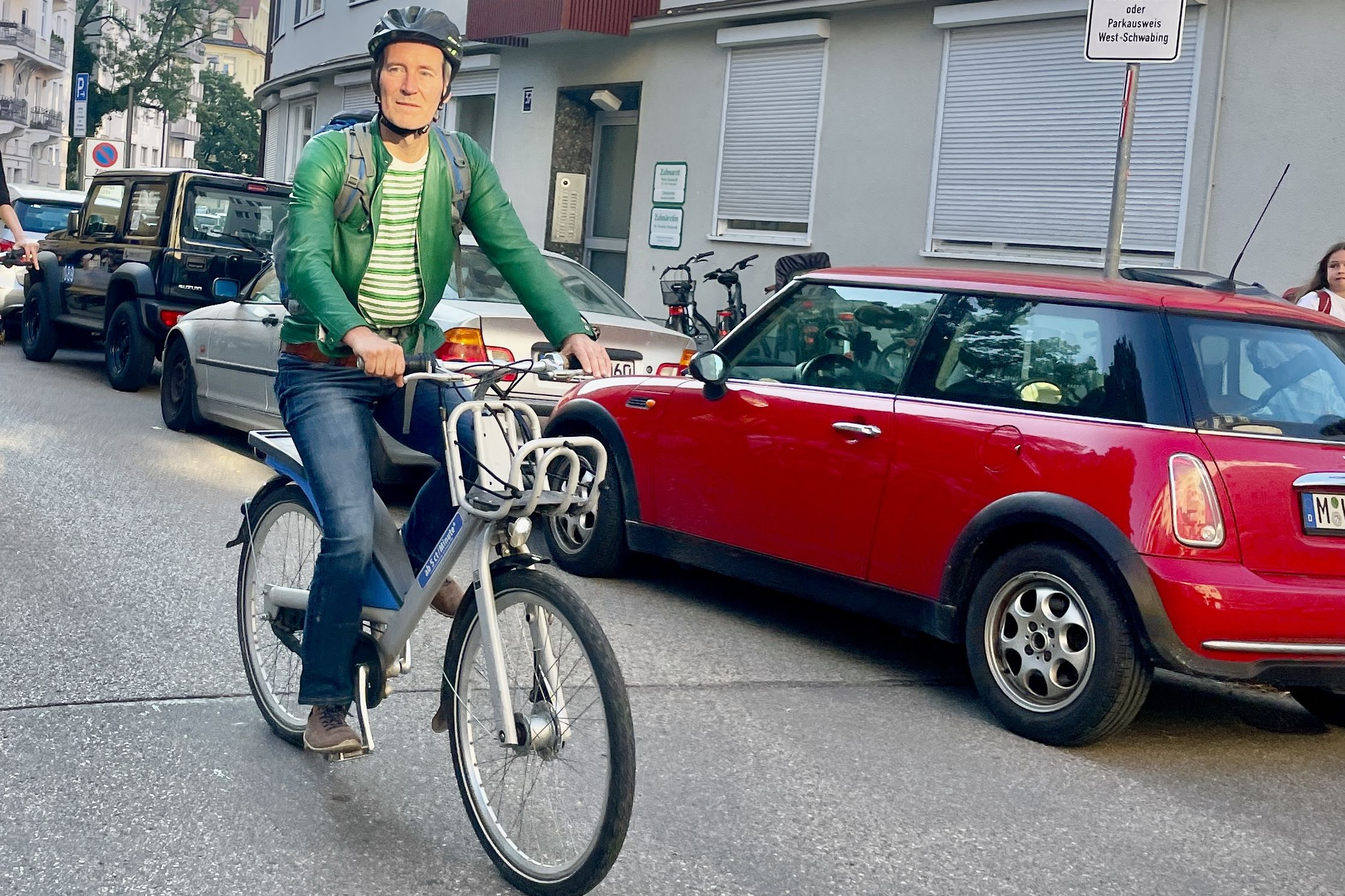 Markus Büchler mit Helm auf Leihfahrrad im Straßenverkehr