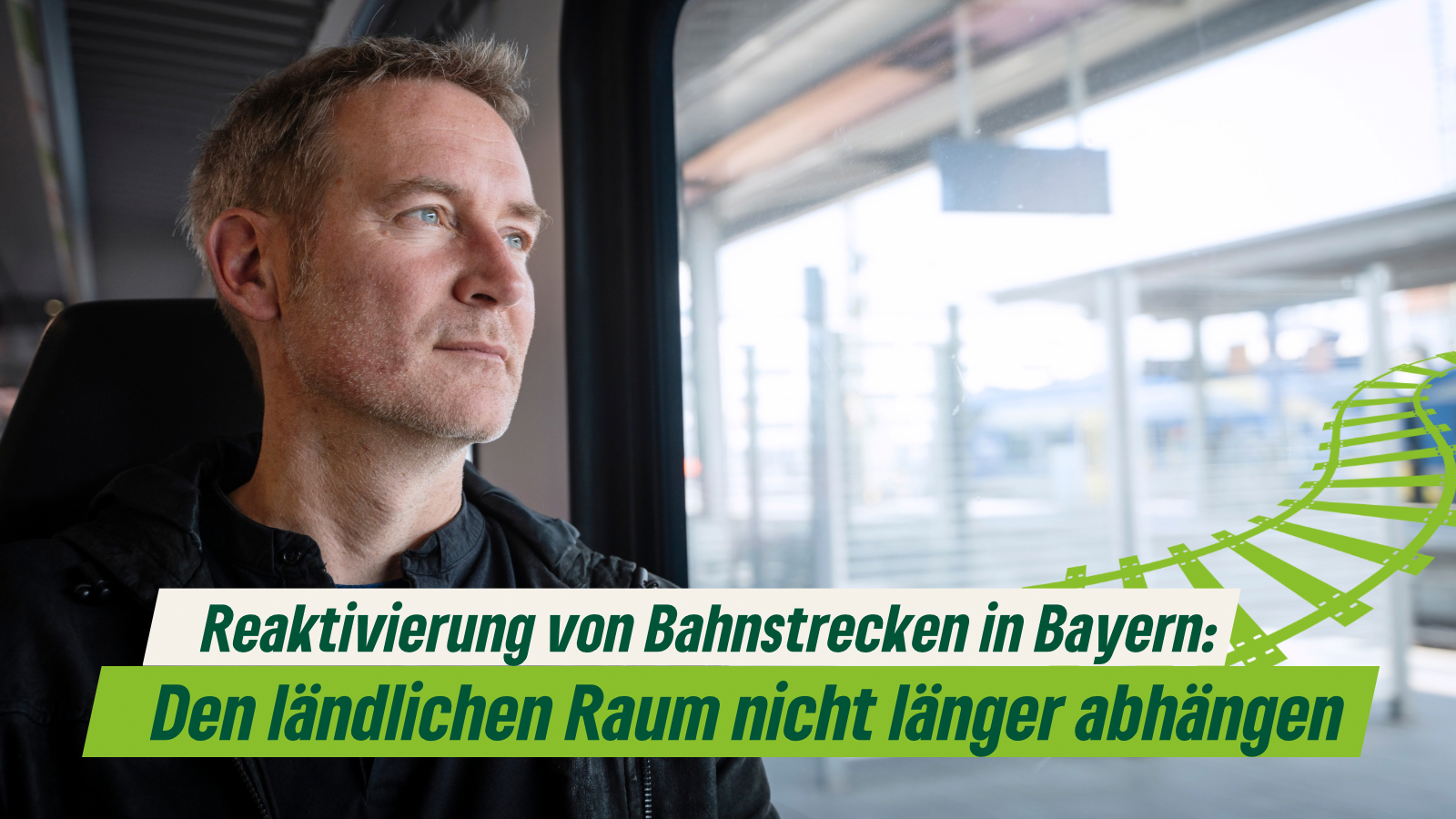 Auf dem Bild zu sehen ist Markus in einer Bahn sitzend und der Titel “ Reaktivierung von Bahnstrecken in Bayern: Den ländlichen Raum nicht länger abhängen!”